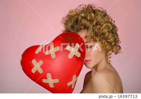 Unhappy young woman with ball in shape of heart Unhappy young woman with ball in shape of heart 16397713