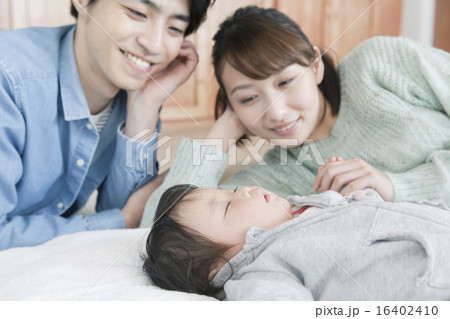 寝ている子供と２０代夫婦 16402410