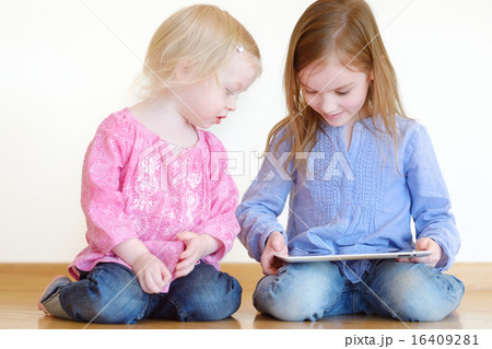 Two children playing with a tablet at home 16409281