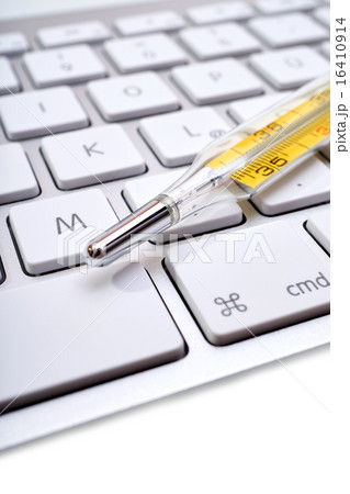 Medical thermometer lies on keyboard 16410914