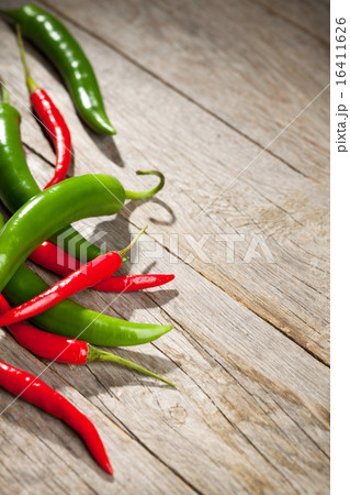 Colorful chili peppers on wooden table Colorful chili peppers on wooden table 16411626