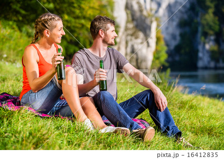 Man and woman having break hiking at river 16412835