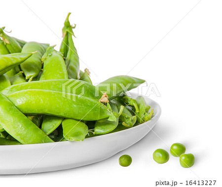 Closeup pile of green peas in pods in white plate 16413227