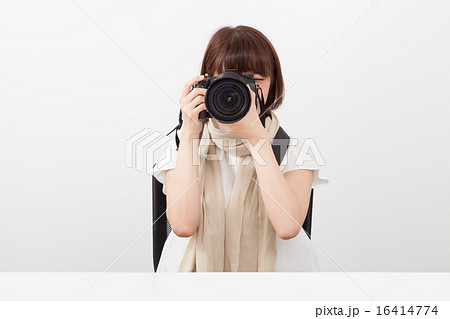 デジタル一眼レフカメラを構える女性の写真素材