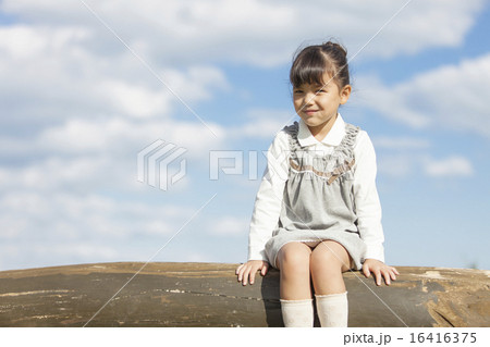 丸太に座っている女の子の写真素材