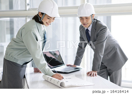 建設現場で打ち合わせをする男女2人 16416414