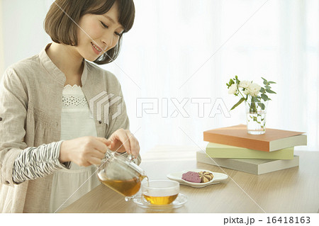 紅茶を注ぐ女性の写真素材