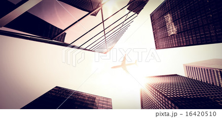 An airplane flying over buildings 16420510