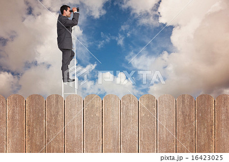 Composite image of businessman standing on ladder using binocula Composite image of businessman standing on ladder using binocula 16423025