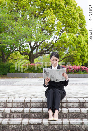 階段に座り新聞を読むビジネス女性 16434638