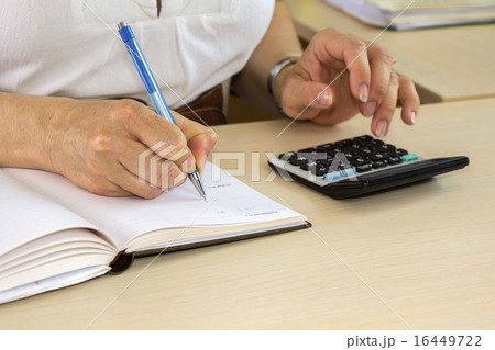 Woman typing on calculator 16449722