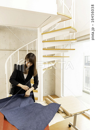 デザイン資料を片付ける女性 16456038