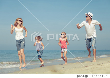 Happy family walking on the beach at the day time Happy family walking on the beach at the day time 16463107