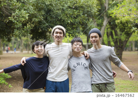 若者 4人 公園 整列 カメラ目線 肩を組むの写真素材
