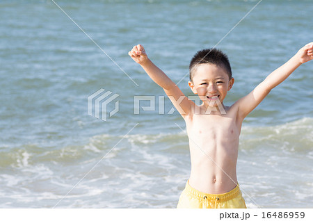 海を背に水着でガッツポーズの写真素材