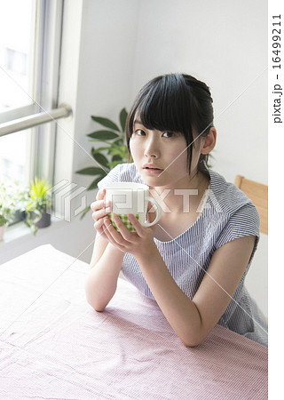 カフェでコーヒーカップを手に持つ女性 16499211