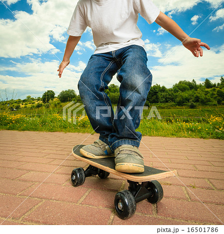 Skater boy child with his skateboard. Outdoor activity. 16501786