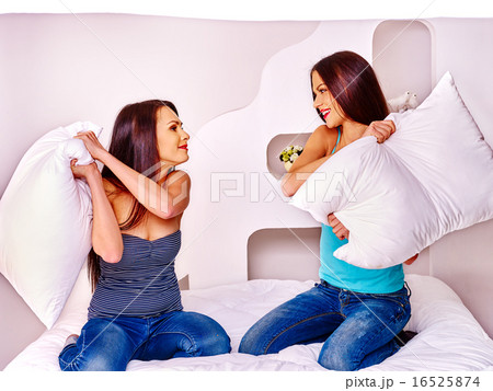 Lesbian women at pillow fights in bed. 16525874