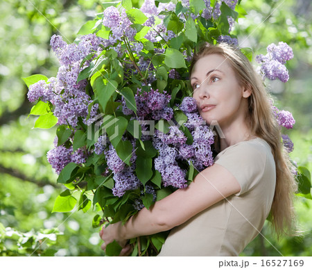 woman in park with a big bouquet of a lilac 16527169