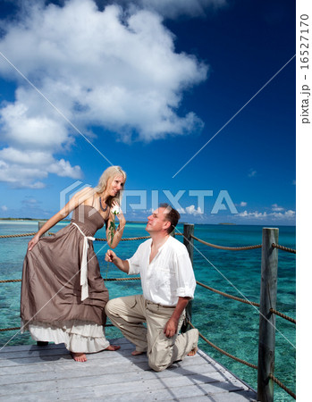 Loving couple on a wooden platform over the sea on Loving couple on a wooden platform over the sea on 16527170