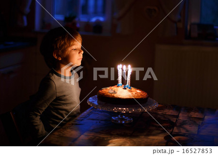Little kid celebrating his birthday and blowing candles on homem 16527853
