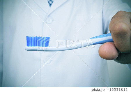 a dentist showing a toothbrush a dentist showing a toothbrush 16531312