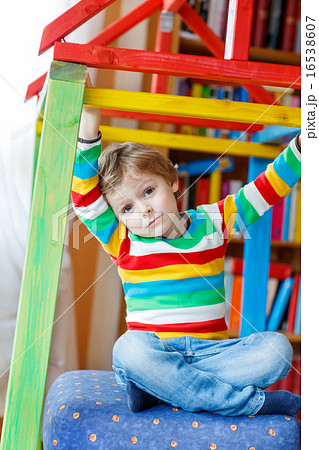 Little blond kid boy playing in selfmade wooden colorful house Little blond kid boy playing in selfmade wooden colorful house 16538607