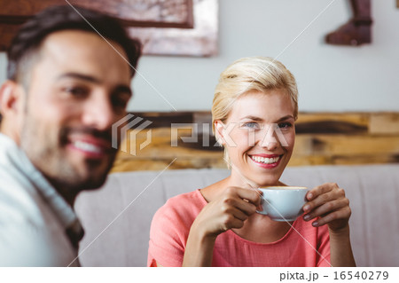 Couple with coffee cup sitting on sofa 16540279
