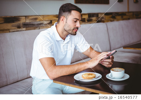 Young man having cup of coffee and pastry Young man having cup of coffee and pastry 16540577
