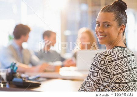 Portrait of smiling young businesswoman with colleagues 16540833