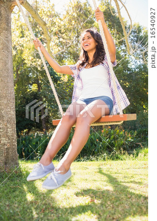 Pretty brunette swinging in park Pretty brunette swinging in park 16540927