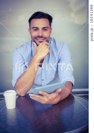 Smiling businessman using a tablet Smiling businessman using a tablet 16541366