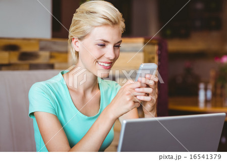Pretty blonde woman using her smartphone 16541379