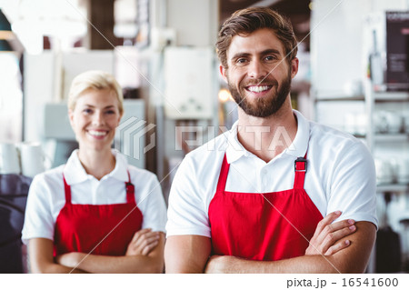 Two baristas smiling at the camera 16541600