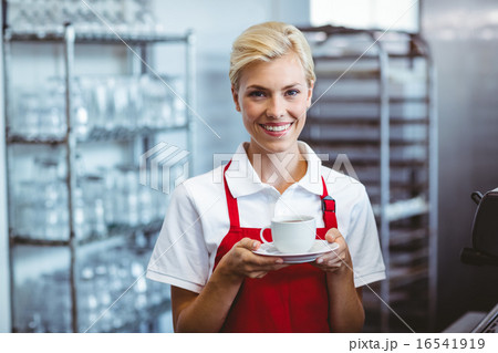 Pretty barista holding a cup of coffee Pretty barista holding a cup of coffee 16541919