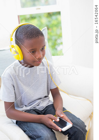Little boy listening to music on the couch 16542064