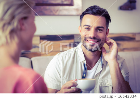 Couple with coffee cup sitting on sofa 16542334
