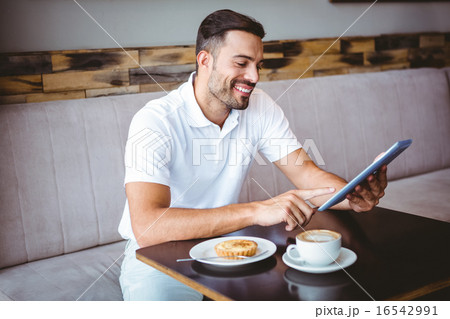 Young man having cup of coffee and pastry Young man having cup of coffee and pastry 16542991