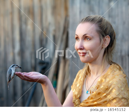 young beautiful woman feeds a bird from a hand 16545152