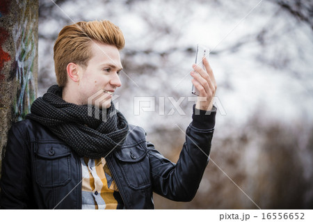 guy taking self picture with phone outdoors 16556652
