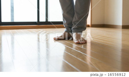 自宅のフローリングに立つ男性の足元 自宅のフローリングに立つ男性の足元 16556912
