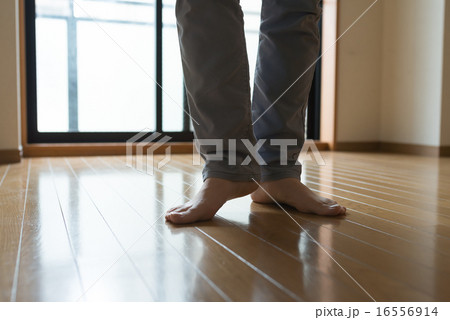 フローリングの床に素足で立つ男性の足元 フローリングの床に素足で立つ男性の足元 16556914