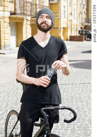Attractive young hipster guy is cycling in city 16557399