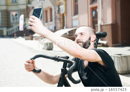 Cheerful young bearded hipster guy in city 16557425