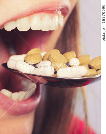 Woman taking eating pills tablets. Drug addict. 16570996