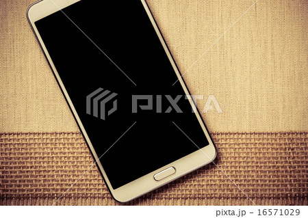 White modern smartphone with blank screen lies on textile. 16571029
