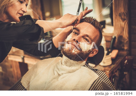 Client during beard shaving in barber shop Client during beard shaving in barber shop 16581994
