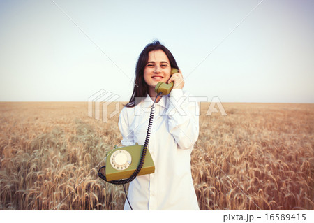 Young brunette girl with green dial handset Young brunette girl with green dial handset 16589415