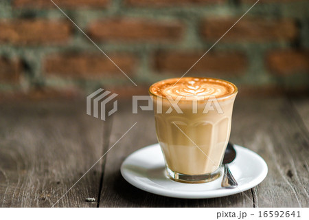 Cup of coffee with tree leaves pattern on wooden Cup of coffee with tree leaves pattern on wooden 16592641