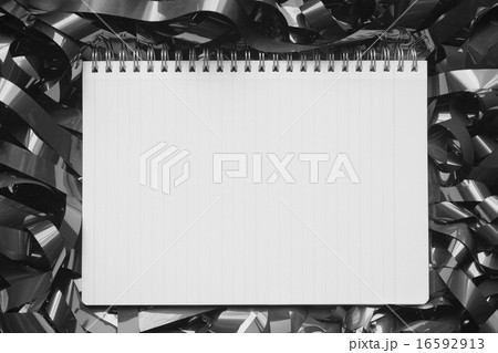 絡まった磁気テープ上のノート　モノクロ 16592913